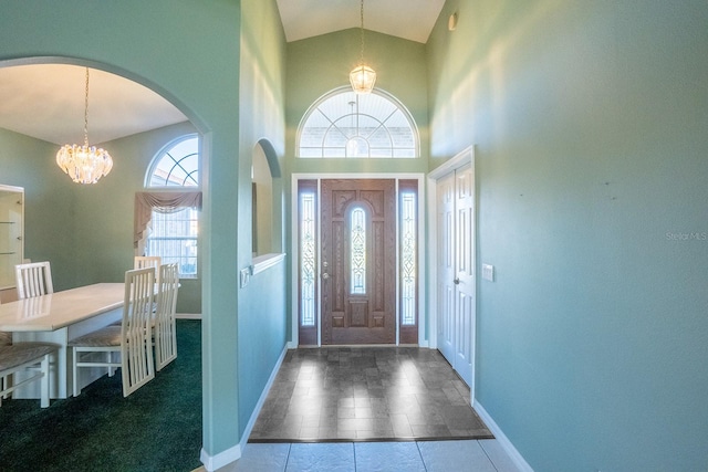 entryway featuring a chandelier, tile patterned flooring, and high vaulted ceiling