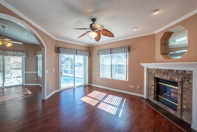 unfurnished living room featuring a textured ceiling, dark hardwood / wood-style floors, ornamental molding, and a fireplace