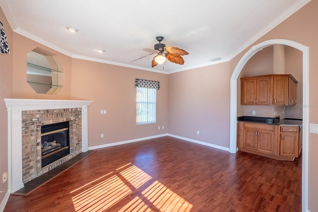 unfurnished living room featuring a fireplace, ceiling fan, dark hardwood / wood-style flooring, and ornamental molding