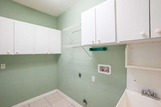 clothes washing area featuring cabinets, hookup for a washing machine, electric dryer hookup, sink, and light tile patterned floors