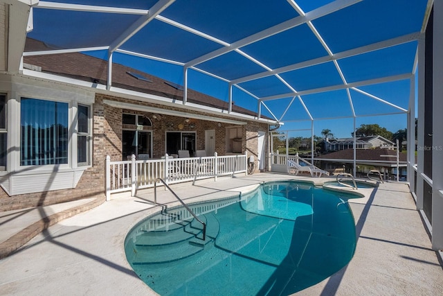 view of pool featuring glass enclosure and a patio