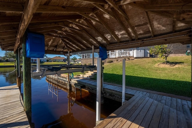 dock area with a lawn and a water view