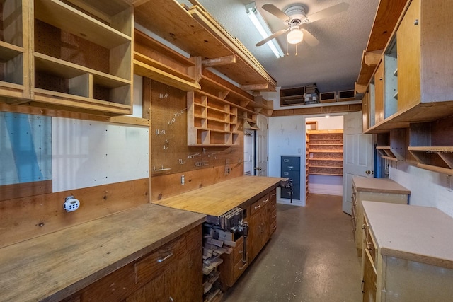 kitchen with wood counters, a textured ceiling, and ceiling fan