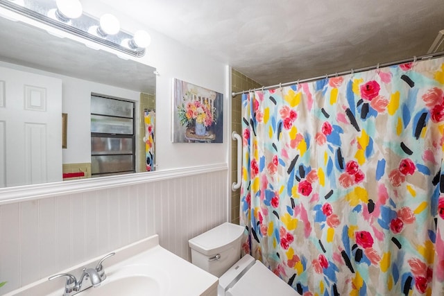 bathroom with walk in shower, vanity, and toilet