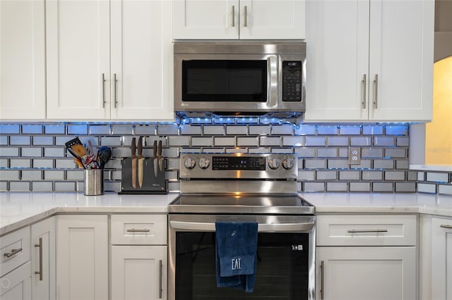 kitchen with white cabinets, light stone countertops, and appliances with stainless steel finishes