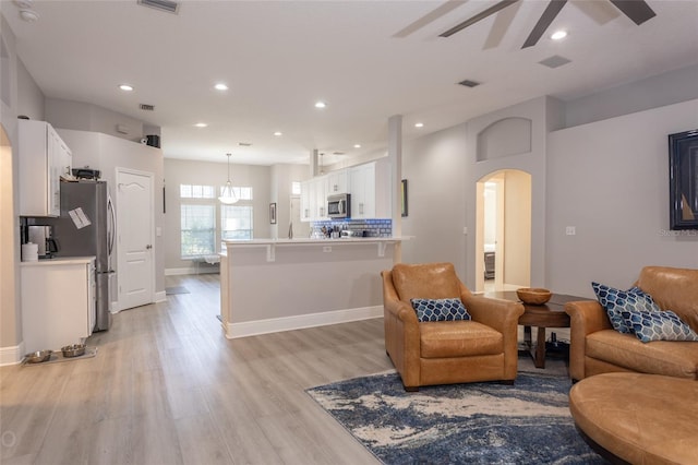 living room with ceiling fan and light hardwood / wood-style floors