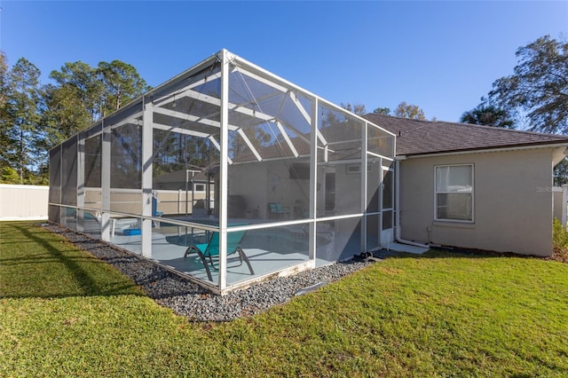 rear view of house with a patio, a fenced in pool, a lanai, and a lawn