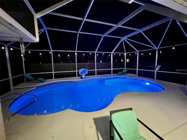 view of pool with glass enclosure and a patio area