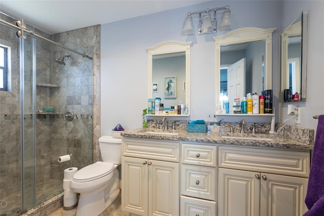 bathroom with vanity, a shower with shower door, and toilet