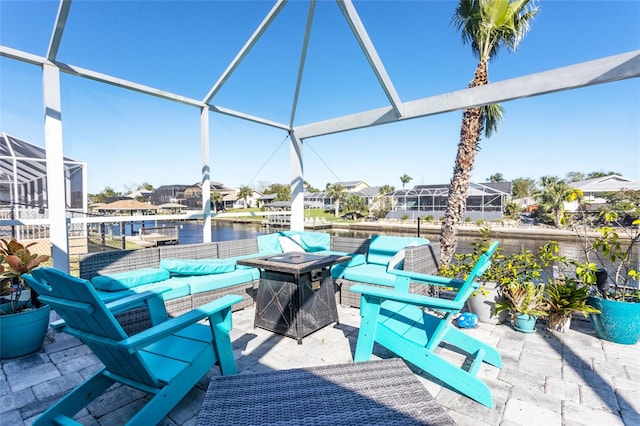 view of patio featuring a fire pit, a lanai, and a water view