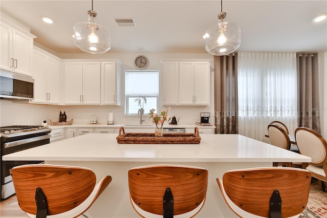 kitchen with a center island, range, and hanging light fixtures