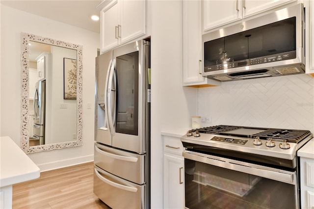 kitchen featuring light hardwood / wood-style floors, white cabinetry, appliances with stainless steel finishes, and tasteful backsplash