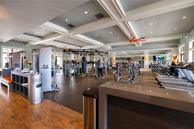 exercise room with ceiling fan, dark hardwood / wood-style flooring, and coffered ceiling