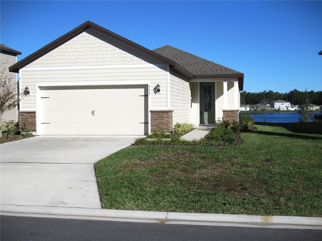 523 Falcon Ridge Rd, Saint Augustine, FL 32084 - view of front facade featuring stone siding, an attached garage, concrete driveway, and a front lawn