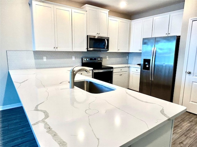 kitchen with light stone countertops, sink, and appliances with stainless steel finishes