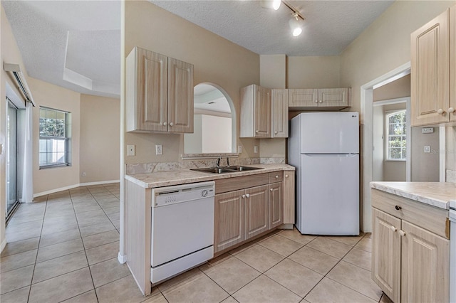 kitchen featuring a textured ceiling, white appliances, light tile patterned floors, and sink