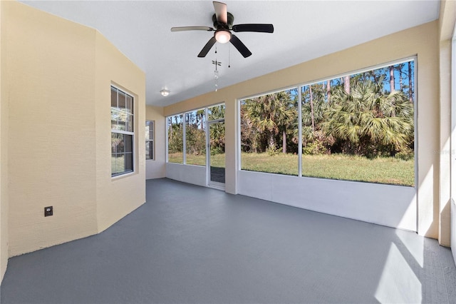 unfurnished sunroom with ceiling fan