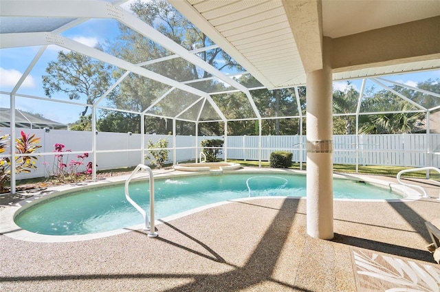 view of pool with an in ground hot tub, glass enclosure, and a patio area