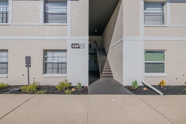 property entrance featuring brick siding and stucco siding