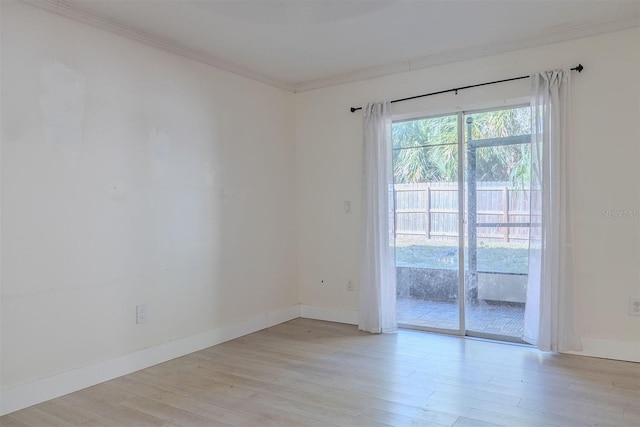 empty room with light wood-style flooring, crown molding, and baseboards