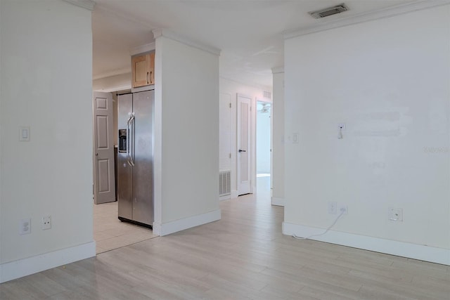 unfurnished room with light wood-type flooring, visible vents, and baseboards