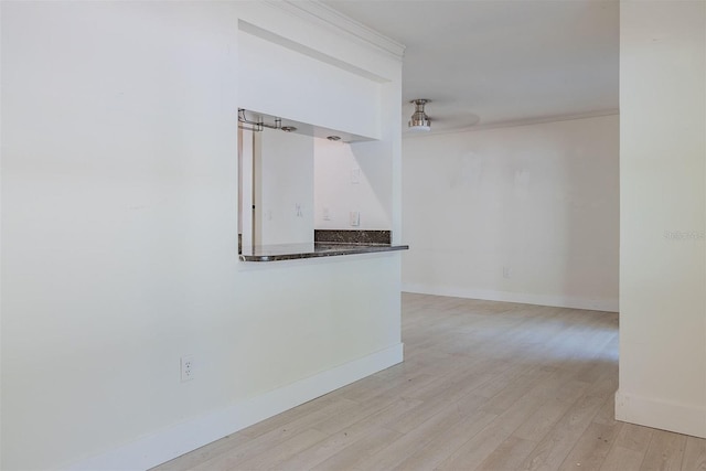 empty room with baseboards and light wood-type flooring