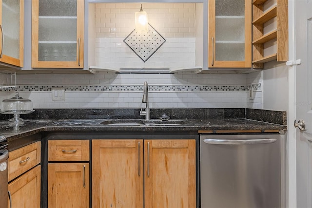 kitchen featuring dark stone counters, a sink, decorative backsplash, glass insert cabinets, and stainless steel dishwasher