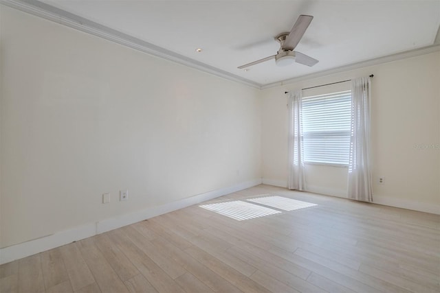 spare room featuring wood finished floors, a ceiling fan, baseboards, and ornamental molding