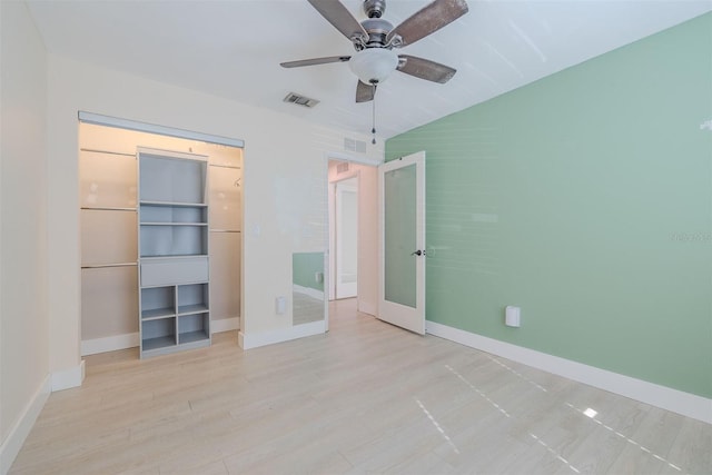 unfurnished bedroom with visible vents, a walk in closet, baseboards, wood finished floors, and a closet