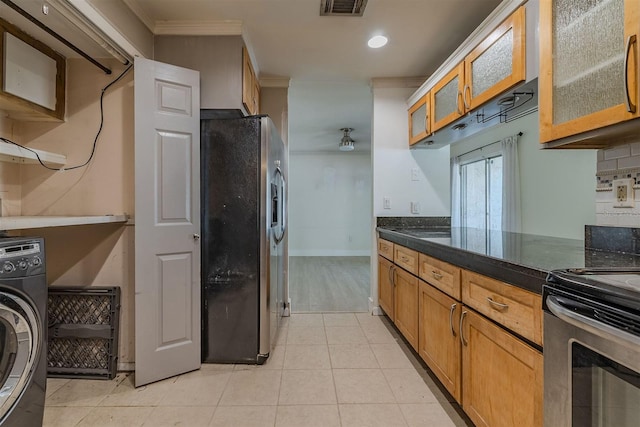 kitchen with light tile patterned floors, visible vents, washer / clothes dryer, stainless steel appliances, and glass insert cabinets