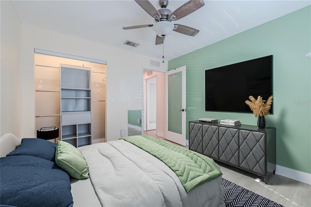 bedroom featuring lofted ceiling, visible vents, baseboards, and ceiling fan