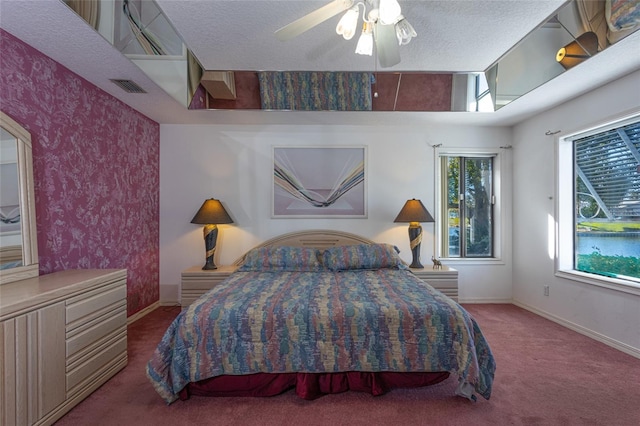 carpeted bedroom featuring multiple windows, a textured ceiling, and ceiling fan