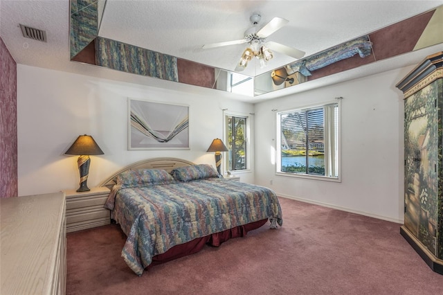 bedroom featuring ceiling fan, carpet floors, and a textured ceiling