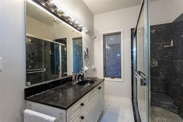 bathroom featuring a textured ceiling, vanity, and a shower with shower door