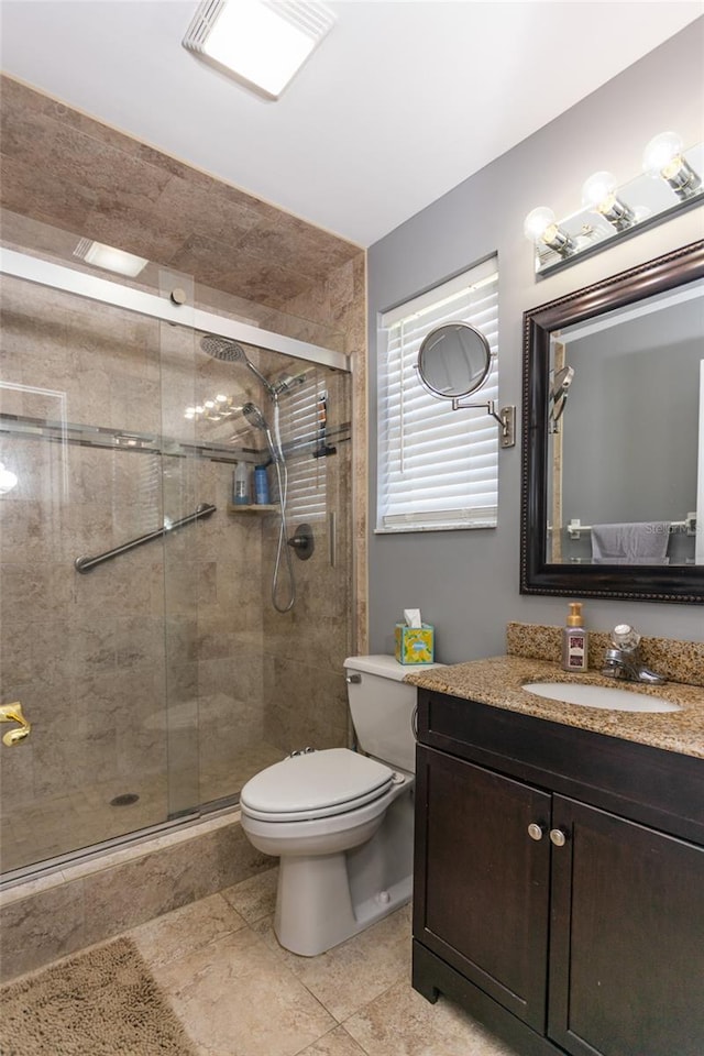 bathroom featuring vanity, toilet, and a shower with door