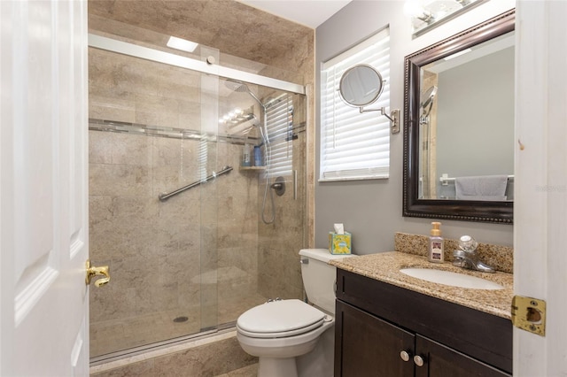 bathroom with vanity, a healthy amount of sunlight, an enclosed shower, and toilet