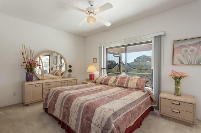 carpeted bedroom featuring multiple windows, access to outside, and ceiling fan