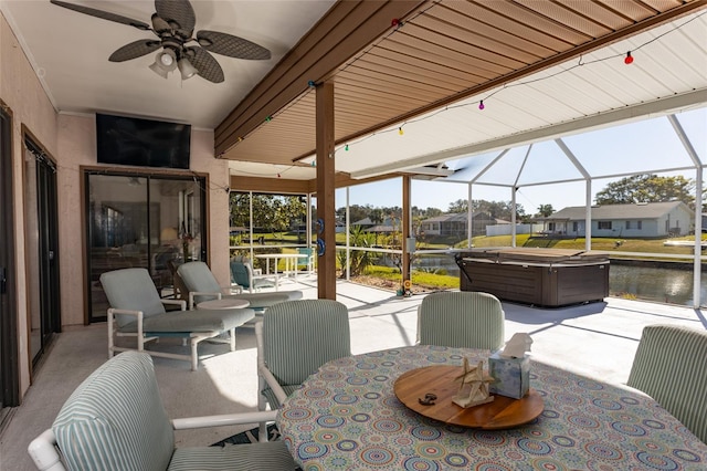 view of patio featuring a water view, a hot tub, ceiling fan, and a lanai