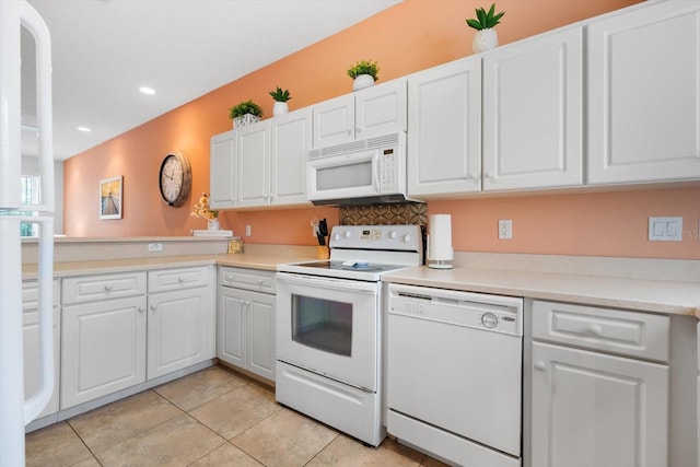 kitchen with white cabinets, white appliances, and light tile patterned floors