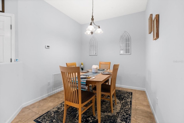 dining room with light tile patterned floors, vaulted ceiling, and a notable chandelier