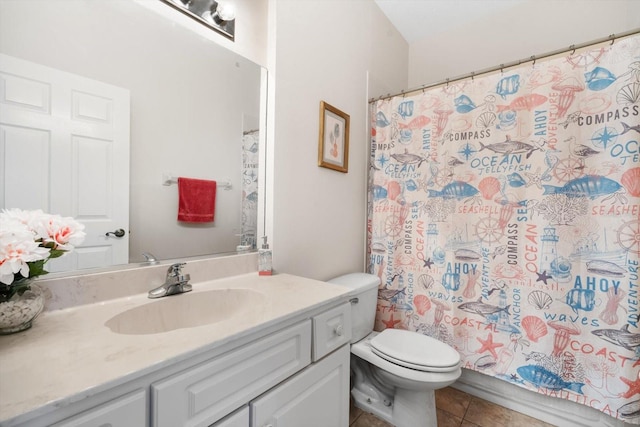 bathroom with toilet, vanity, and tile patterned floors