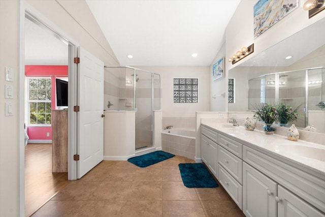 bathroom featuring tile patterned flooring, vanity, independent shower and bath, and lofted ceiling