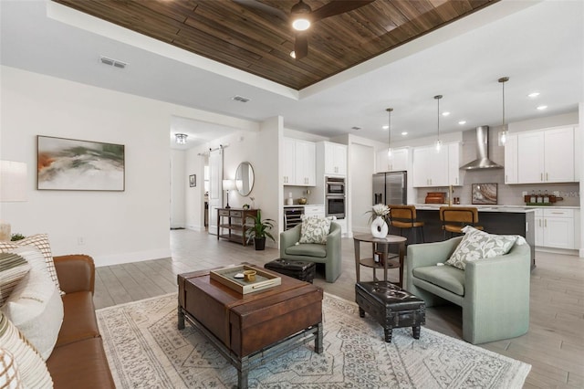 19 Essex Ln, Palm Coast, FL 32164 - living area with light wood-style flooring, visible vents, a ceiling fan, a tray ceiling, and wood ceiling