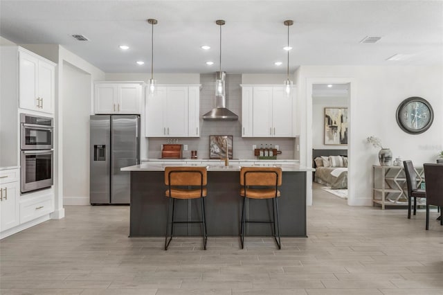 19 Essex Ln, Palm Coast, FL 32164 - kitchen featuring wall chimney exhaust hood, light countertops, visible vents, and stainless steel appliances