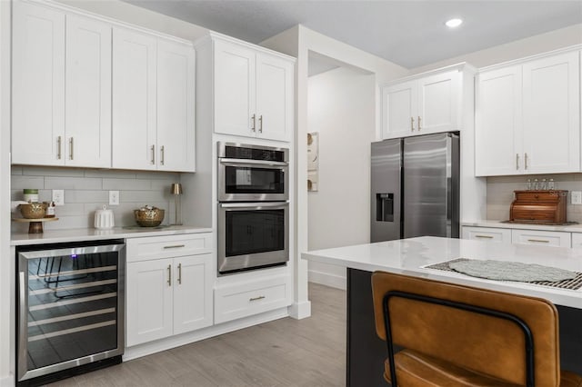 19 Essex Ln, Palm Coast, FL 32164 - kitchen featuring light wood-style flooring, stainless steel appliances, tasteful backsplash, and wine cooler