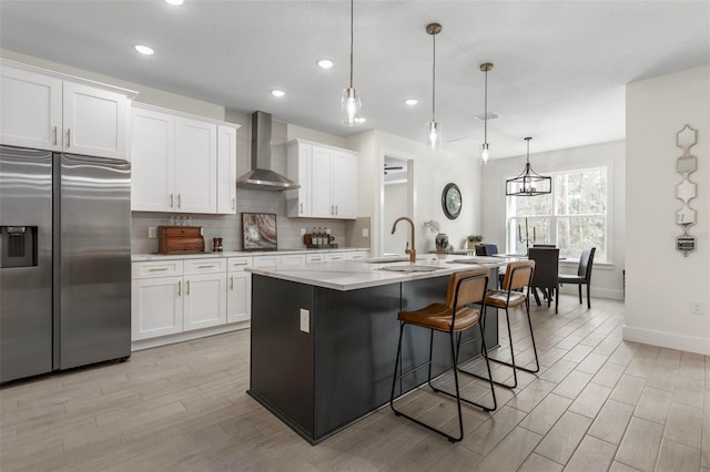 19 Essex Ln, Palm Coast, FL 32164 - kitchen with white cabinets, tasteful backsplash, a sink, stainless steel fridge with ice dispenser, and wall chimney range hood