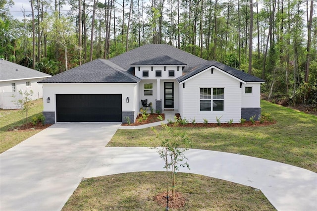 19 Essex Ln, Palm Coast, FL 32164 - view of front of home with an attached garage, concrete driveway, a front lawn, stucco siding, and a shingled roof