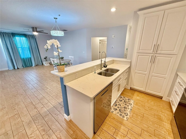 kitchen featuring sink, hanging light fixtures, stainless steel dishwasher, kitchen peninsula, and light wood-type flooring