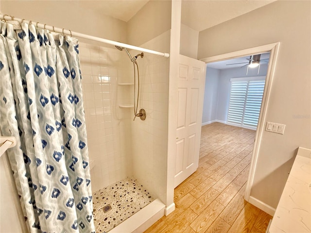 bathroom featuring ceiling fan, wood-type flooring, and a shower with shower curtain