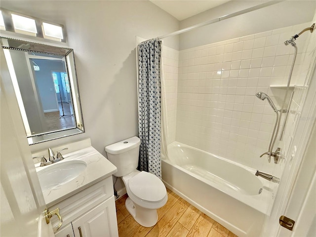 full bathroom with hardwood / wood-style floors, vanity, shower / tub combo, and toilet